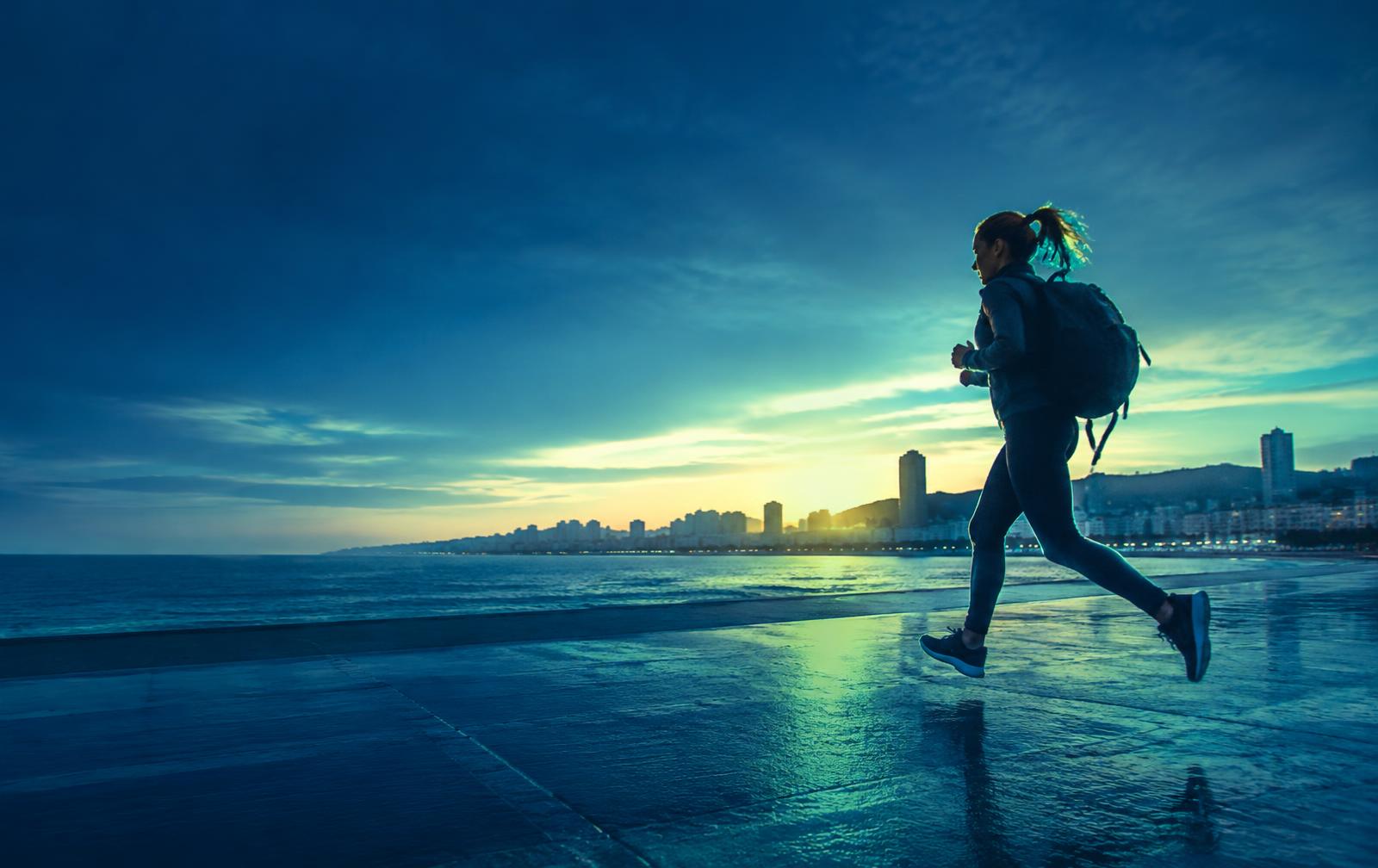Runner on a coastal promenade at dawn